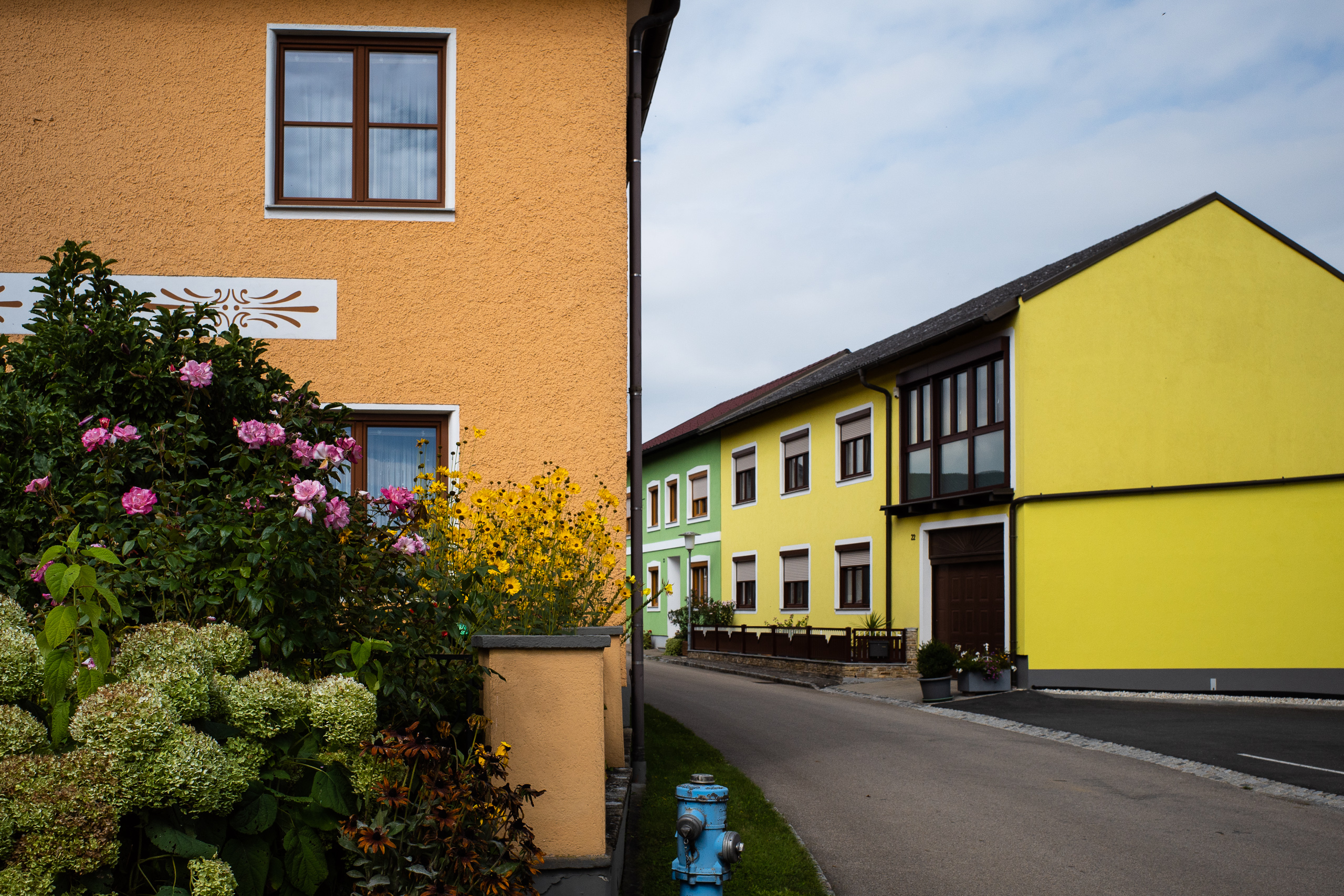 Zurück in Österreich: kräftig gestrichene Häuser in Gelb, Grün und Orange